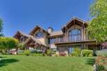 This stunning luxury home boasts a striking architectural design with a warm, inviting exterior.