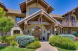 Discover this stunning mountain-style home featuring a grand arched wooden entryway, complemented by exposed timber beams and natural stone accents.