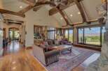 Experience luxurious living in this stunning great room, featuring soaring vaulted ceilings with exposed wooden beams and a grand stone fireplace.