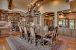 Experience luxurious dining in this grand estate, featuring a spacious dining room with a large wooden table and ornate chairs, perfect for hosting.