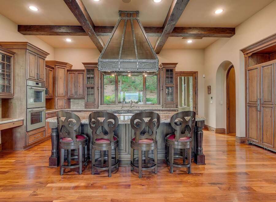 Experience luxury in this stunning kitchen featuring custom wood cabinetry and a grand copper range hood.