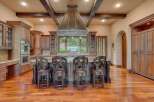 Experience luxury in this stunning kitchen featuring custom wood cabinetry and a grand copper range hood.