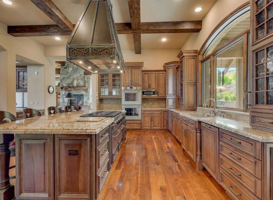 Experience luxury in this expansive gourmet kitchen, featuring custom wood cabinetry and a grand granite island perfect for entertaining.