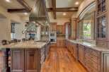 Experience luxury in this expansive gourmet kitchen, featuring custom wood cabinetry and a grand granite island perfect for entertaining.