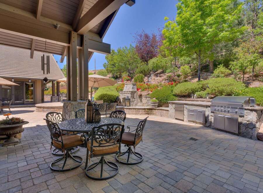 Experience luxurious outdoor living with this stunning patio featuring a built-in gourmet grill and a cozy dining area perfect for al fresco meals.