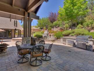 Experience luxurious outdoor living with this stunning patio featuring a built-in gourmet grill and a cozy dining area perfect for al fresco meals.