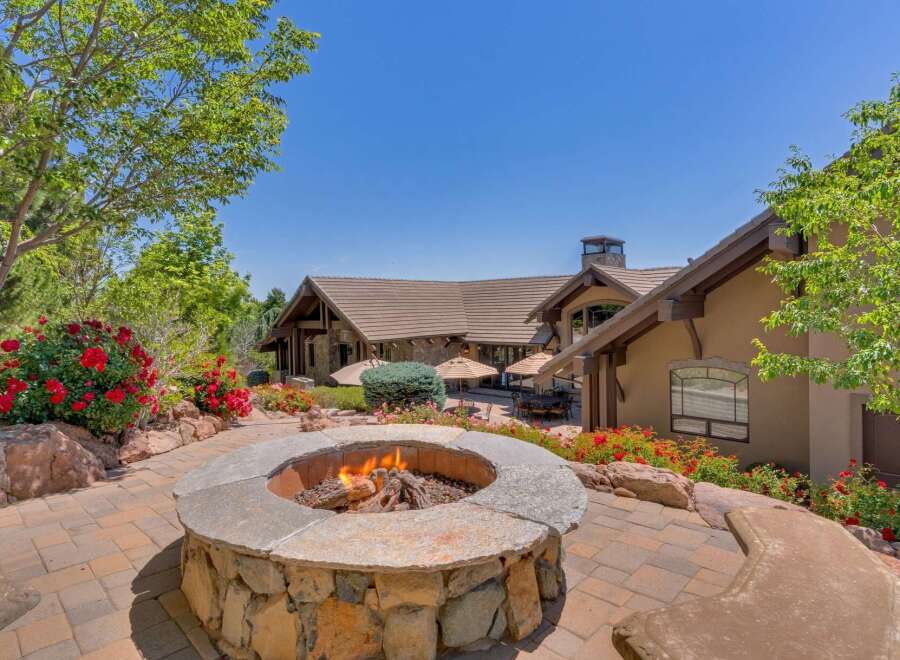 Experience luxurious outdoor living with this stunning patio featuring a built-in stone fire pit, perfect for cozy evenings.