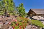 Experience the beauty of this stunning property, featuring a charming stone-accented home nestled amidst lush greenery and vibrant floral gardens.