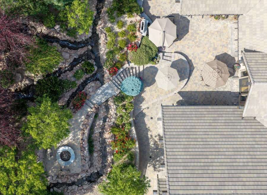 Discover an entertainer's paradise with this stunning backyard oasis, featuring a serene water feature and a cozy fire pit area perfect for gathering.