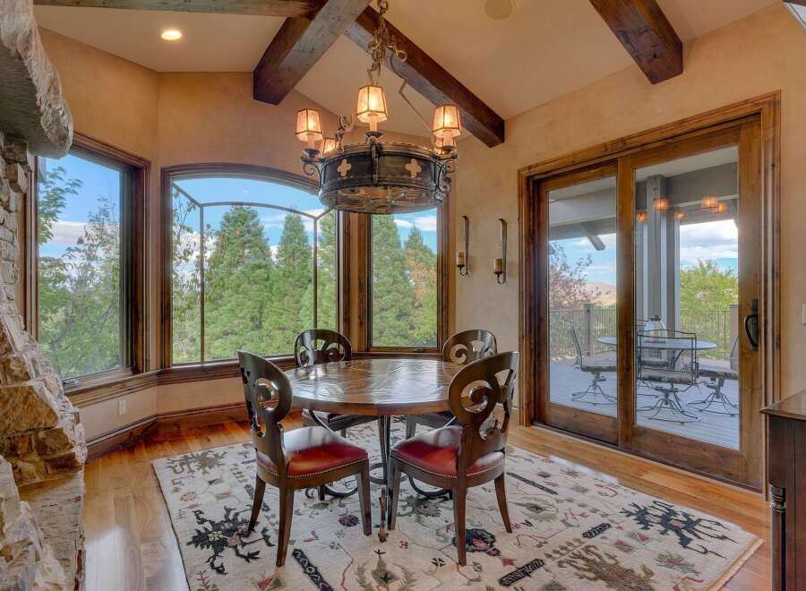 Experience breathtaking views from this elegant dining area, featuring a round wooden table with four ornate chairs perfect for intimate gatherings.