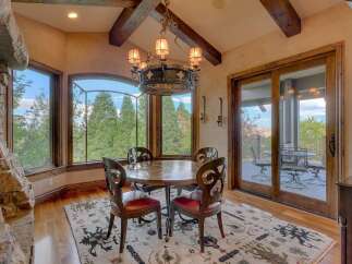 Experience breathtaking views from this elegant dining area, featuring a round wooden table with four ornate chairs perfect for intimate gatherings.