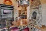 Experience rustic elegance in this dining area, featuring a grand stone fireplace and a polished wooden table perfect for gatherings.