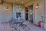Enjoy outdoor living with this charming patio featuring a cozy stone fireplace and a dining set perfect for al fresco meals.