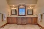This luxurious bathroom features a double vanity with granite countertops and custom wood cabinetry, perfect for ample storage.