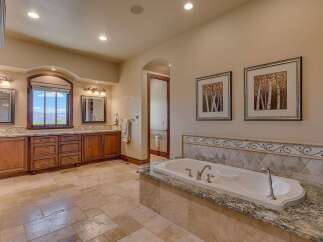 Indulge in luxury in this spacious master bathroom, featuring a deep soaking tub perfect for relaxation.