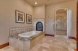 Indulge in luxury with this stunning bathroom featuring a deep soaking tub and a cozy fireplace, perfect for relaxation.