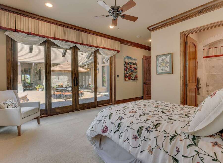 Experience luxurious indoor-outdoor living with this stunning bedroom featuring expansive sliding glass doors that open to a private patio.