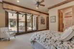 Experience luxurious indoor-outdoor living with this stunning bedroom featuring expansive sliding glass doors that open to a private patio.