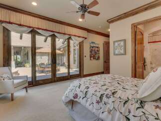 Experience luxurious indoor-outdoor living with this stunning bedroom featuring expansive sliding glass doors that open to a private patio.