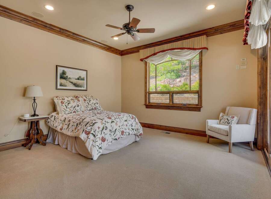 Experience serene living in this charming bedroom, featuring a comfortable queen-size bed adorned with a floral comforter.