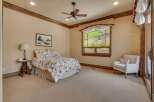Experience serene living in this charming bedroom, featuring a comfortable queen-size bed adorned with a floral comforter.