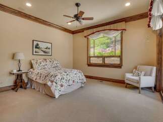 Experience serene living in this charming bedroom, featuring a comfortable queen-size bed adorned with a floral comforter.