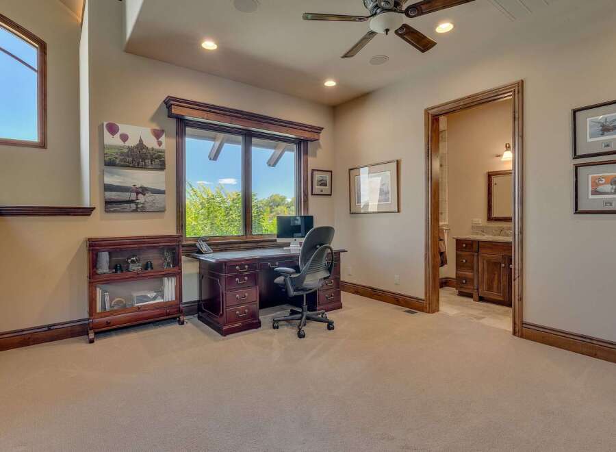 This home office features a large wooden desk with a computer and an ergonomic chair, perfect for productivity.