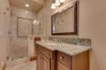 Indulge in luxury with this beautifully appointed bathroom featuring a spacious walk-in shower with intricate tile work and a rainfall showerhead.
