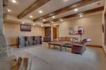 This rustic basement living area features a full-service bar with ample seating, perfect for entertaining guests.