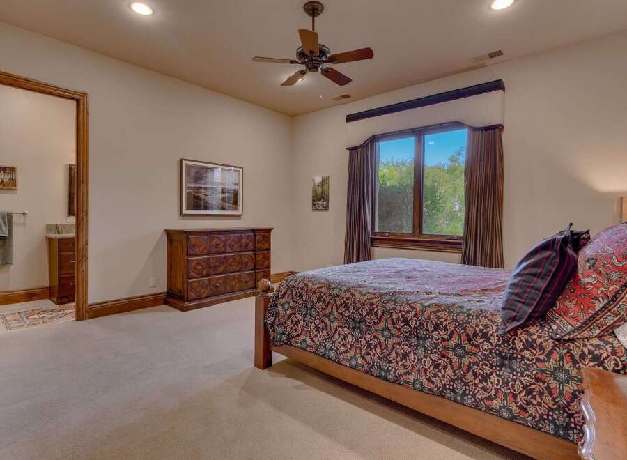 This inviting bedroom features a comfortable queen-size bed adorned with a richly patterned comforter and decorative pillows.