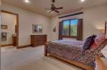 This inviting bedroom features a comfortable queen-size bed adorned with a richly patterned comforter and decorative pillows.
