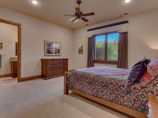This inviting bedroom features a comfortable queen-size bed adorned with a richly patterned comforter and decorative pillows.