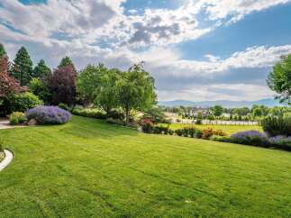 Experience the epitome of luxury living with this stunning property, boasting meticulously manicured lawns and vibrant floral arrangements.