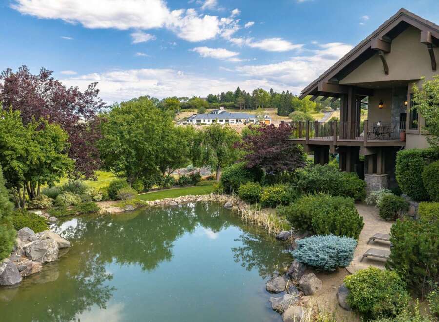 Experience luxurious living with this stunning property featuring a serene pond and lush landscaping, perfect for outdoor enjoyment.