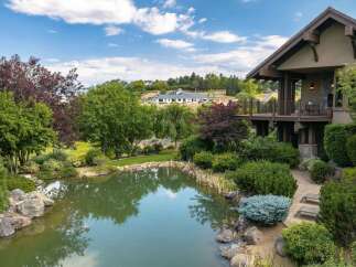 Experience luxurious living with this stunning property featuring a serene pond and lush landscaping, perfect for outdoor enjoyment.