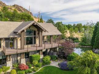 Experience luxury living in this stunning home, featuring expansive decks overlooking a serene pond and lush landscaping.
