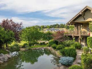 Experience luxurious living with this stunning property featuring a serene pond and lush landscaping, perfect for outdoor enjoyment.