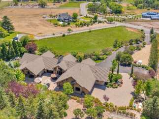 Discover this sprawling estate featuring a magnificent home with multiple wings and a large, tiled roof.