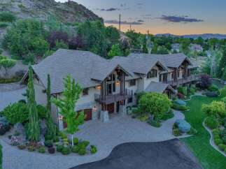 Experience luxury living in this stunning mountain-view estate, featuring a grand entrance with a paver driveway leading to a spacious multi-car garage.