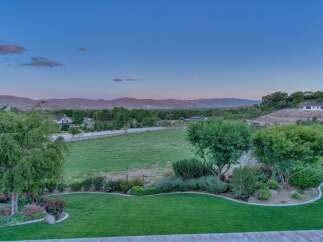 Experience serene country living with this stunning property, featuring a sprawling green lawn and meticulously landscaped gardens.
