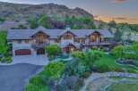 Experience luxury living in this stunning mountain estate, featuring a grand entrance, expansive windows, and multiple balconies offering breathtaking views.