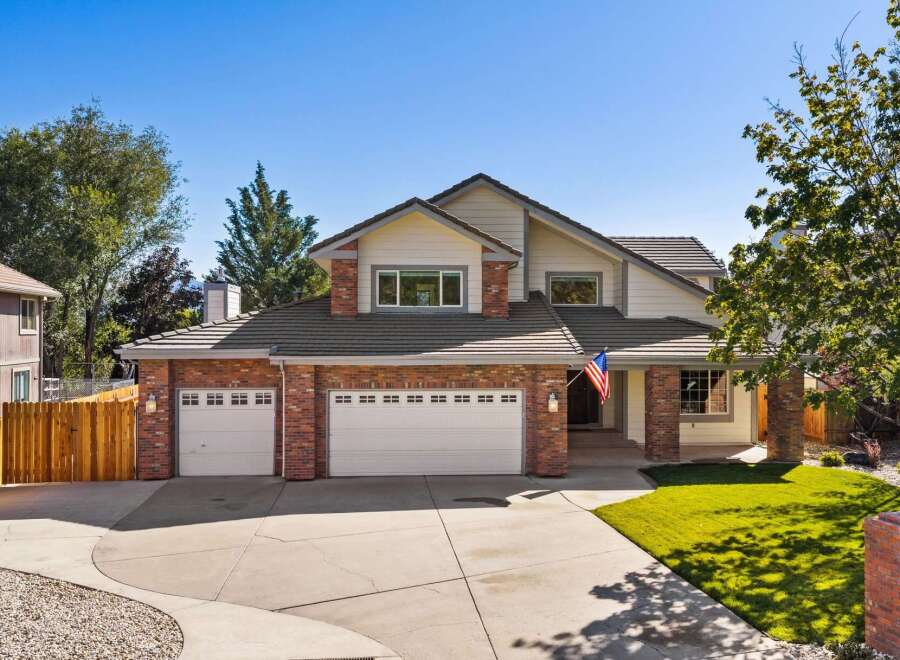 This stunning home boasts a charming brick exterior complemented by a spacious three-car garage, perfect for any car enthusiast.