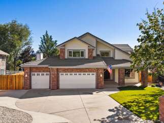 This stunning home boasts a charming brick exterior complemented by a spacious three-car garage, perfect for any car enthusiast.