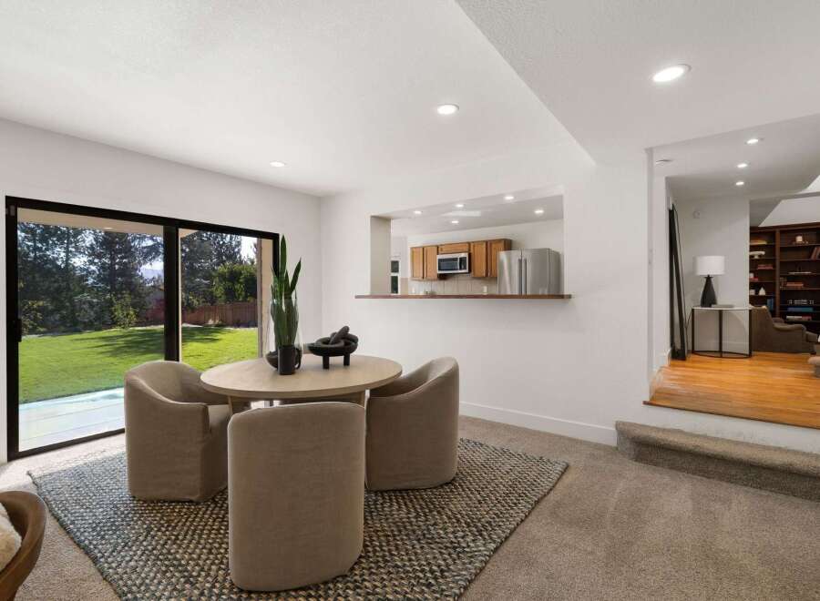 Enjoy a bright and airy dining space with a large sliding glass door that opens to a lush green backyard.