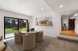 Enjoy a bright and airy dining space with a large sliding glass door that opens to a lush green backyard.