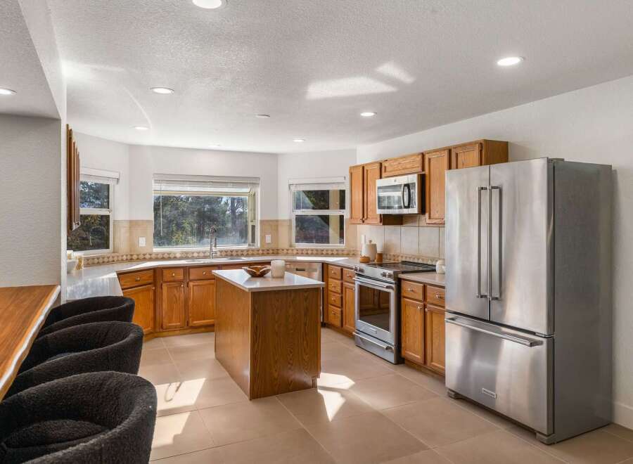 This spacious kitchen boasts beautiful oak cabinetry and a large central island, perfect for meal preparation and casual dining.