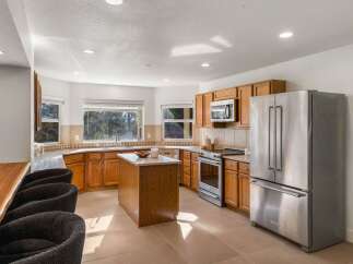 This spacious kitchen boasts beautiful oak cabinetry and a large central island, perfect for meal preparation and casual dining.