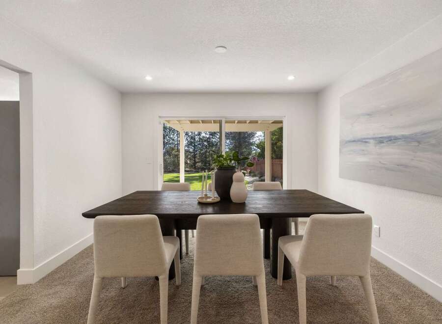 This dining room features a large, dark wood dining table with four upholstered chairs, perfect for family meals and entertaining.