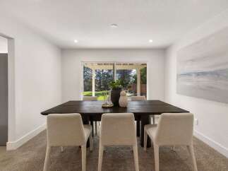 This dining room features a large, dark wood dining table with four upholstered chairs, perfect for family meals and entertaining.