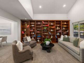 Step into this inviting living room, featuring a grand floor-to-ceiling bookshelf perfect for displaying your literary collection.